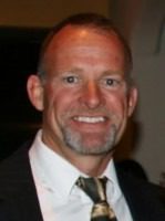 Smiling man in a suit and tie.